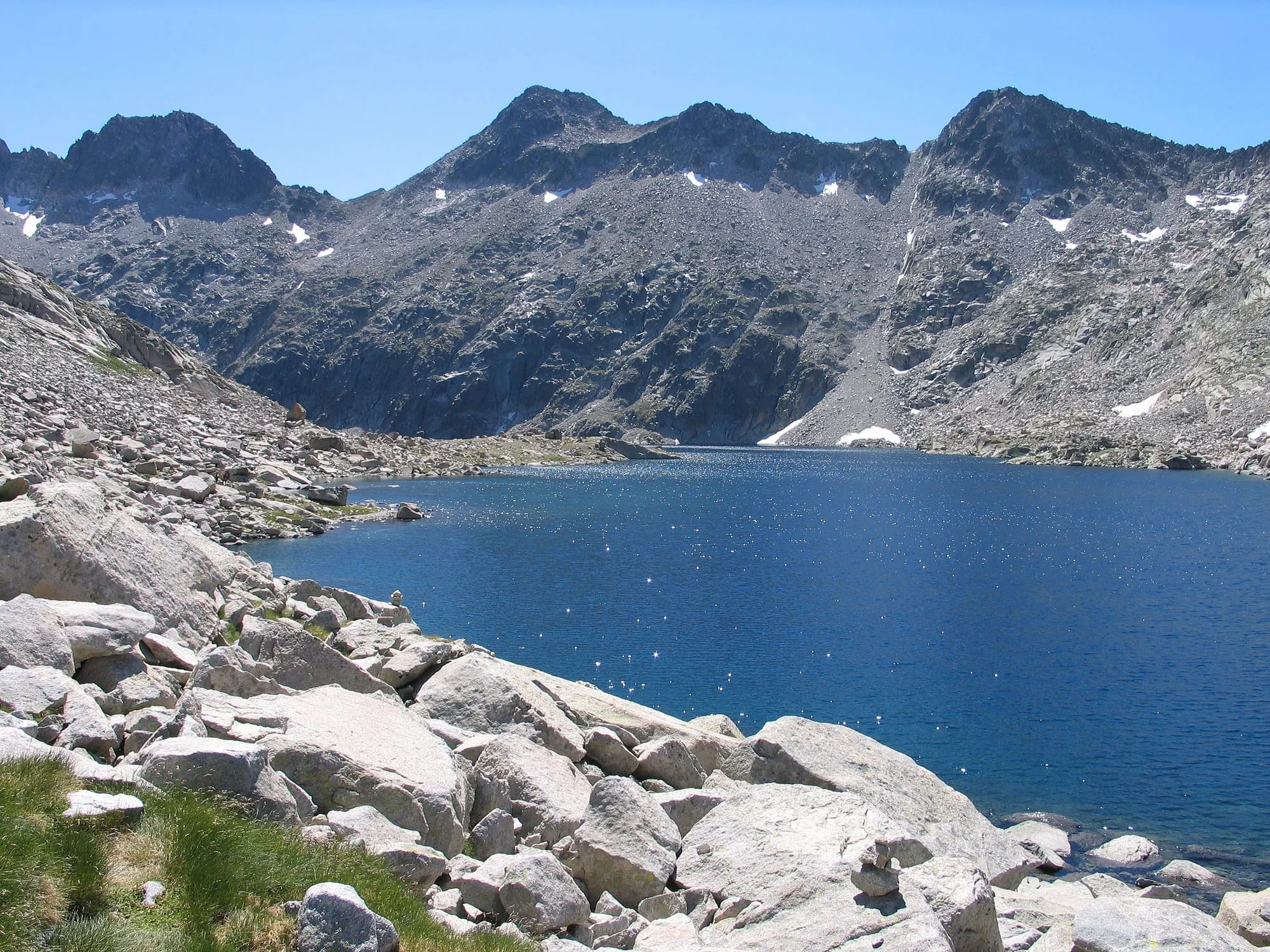 El Ibón de Cregüeña visto desde la orilla, con las montañas del macizo de Posets-Maladeta reflejadas en el agua