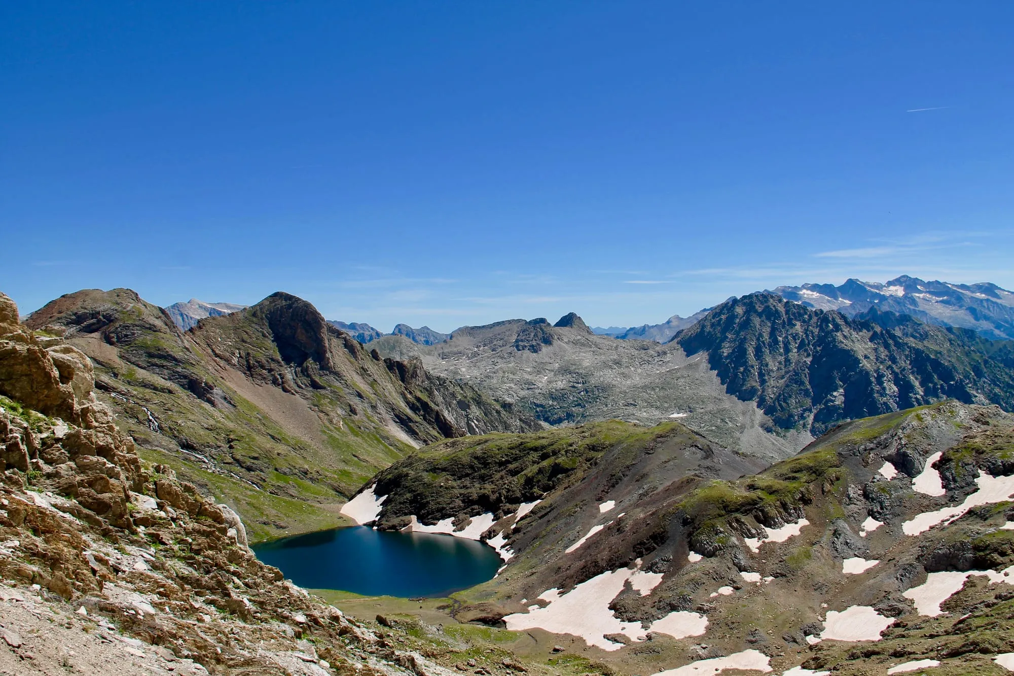 El Ibón de la Llardaneta, un lago de alta montaña en el macizo de Posets-Maladeta, con picos nevados reflejados en el agua