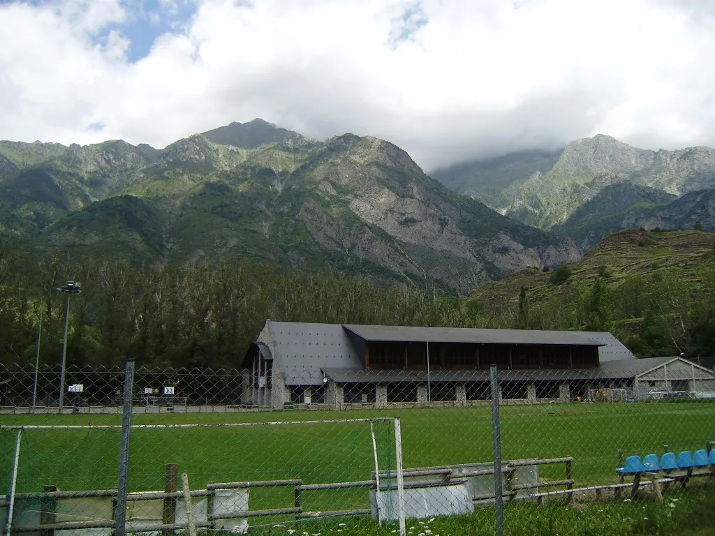 Pabellón deportivo de Benasque, con el campo de fútbol delante y los Pirineos al fondo